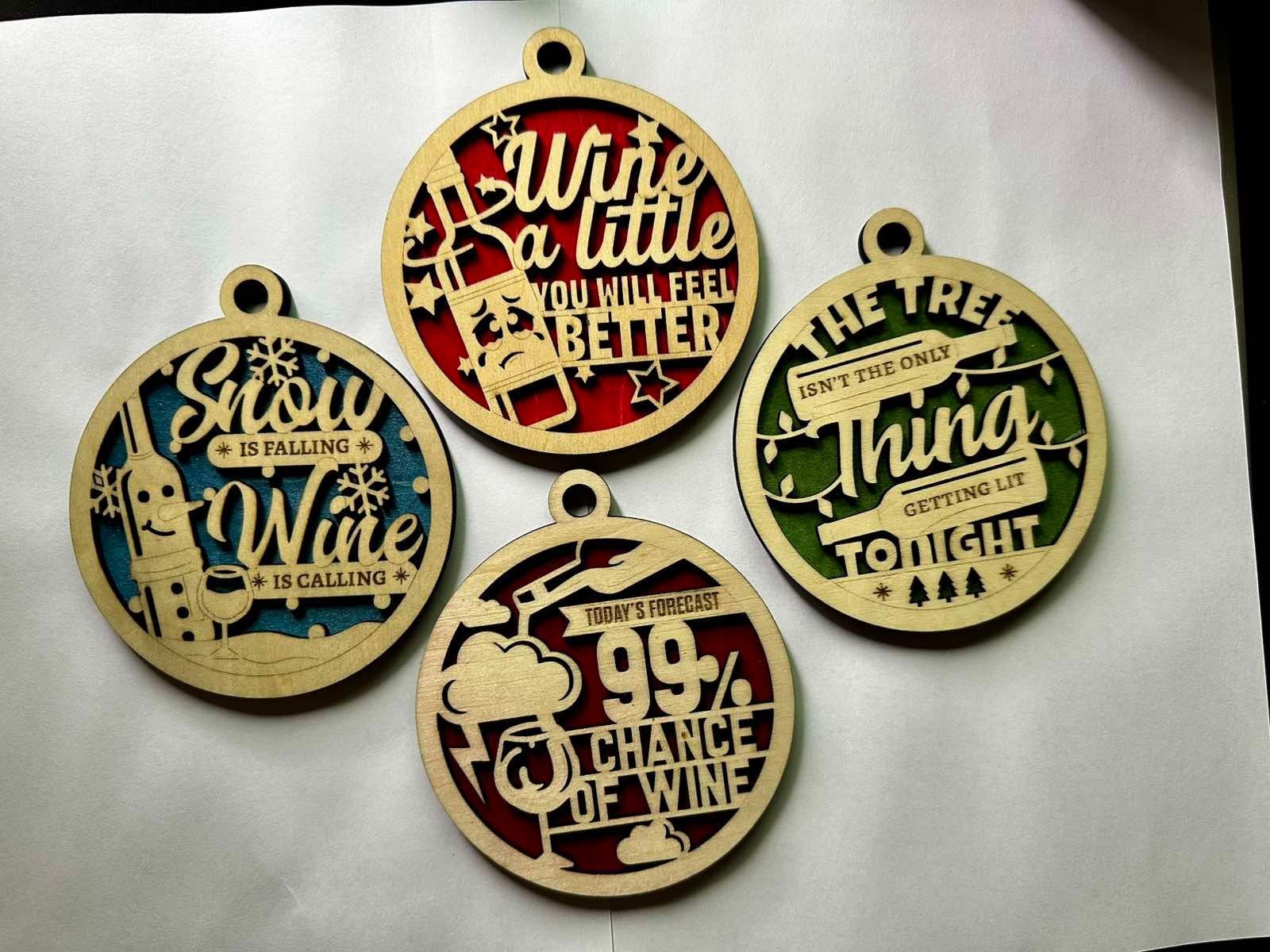 Four wooden holiday ornaments with humorous wine-related sayings and designs on a white background.